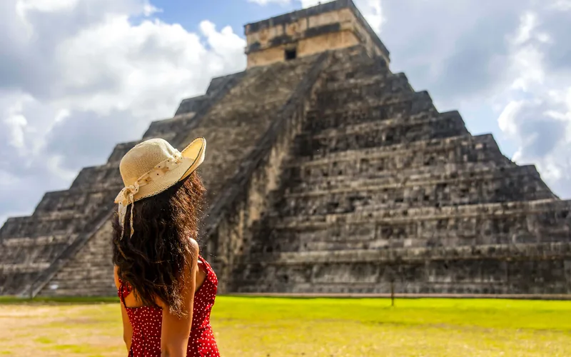 A visitor in front of the pyramid of Kukulkán